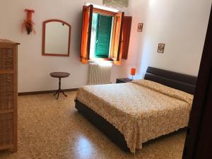 福利亚Poggio dei Michelazzi的一间卧室配有一张床、镜子和窗户
