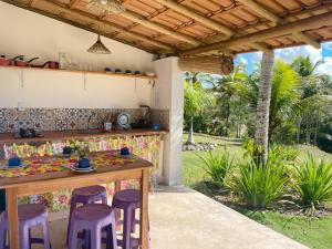 库穆鲁沙蒂巴Canto do Mar - Chalés com vista pro Mar - Cumuruxatiba的院子里的厨房,配有桌子和凳子