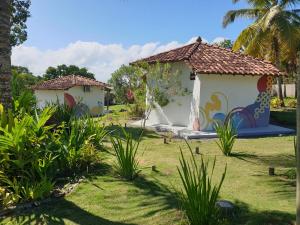 库穆鲁沙蒂巴Canto do Mar - Chalés com vista pro Mar - Cumuruxatiba的院子里的一座房子,上面有绘画
