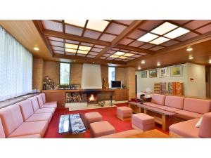 YokokuraOyado Kotobuki - Vacation STAY 97600v的客厅配有粉红色的沙发和壁炉