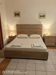 莫斯塔尔Lovely Bosnian Home的一间卧室配有一张带白色床单的大床和两张桌子