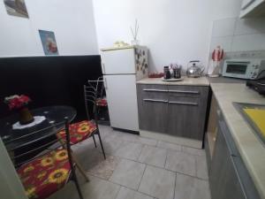 AcerraAL Civico 24的厨房配有白色冰箱、桌子和椅子
