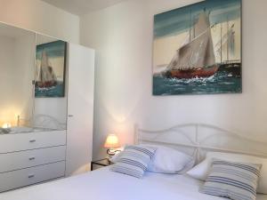 波尔Apartments Eastern Paradise的卧室配有白色的床和一张帆船画