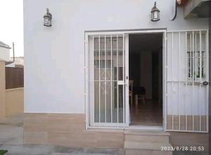 赫雷斯-德拉弗龙特拉Casa en Jerez con patio cerca de la playa y de la sierra的两盏灯的白色房子的敞开门