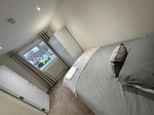 奥平顿5 bedroom house in Orpington的一间卧室设有一张大床和一个窗户。