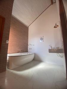 圣安东尼奥-杜皮尼亚尔Pousada Estância da Pinha的白色的浴室设有浴缸和水槽。