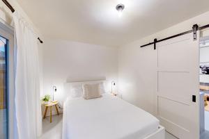圣地亚哥Casita Azul的白色的卧室设有床和窗户