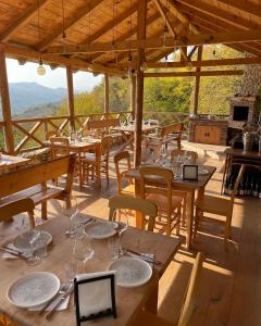 安布罗劳里Sad Meli Wines的一间设有木桌和椅子的餐厅,享有美景