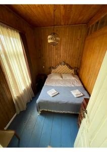 安布罗劳里Sad Meli Wines的木制客房内的一间卧室,配有一张床