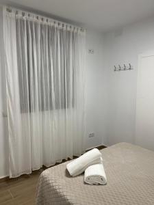 奥尔纳丘埃洛斯CASA MARTÍN的一间卧室配有一张床,上面有两条毛巾