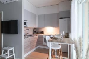 库奥皮奥City Apartment Kallaveden Marina的厨房配有白色橱柜和桌椅