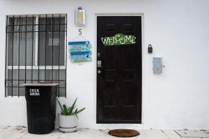 坎昆Casa Aurora的黑色的门,上面有欢迎标志