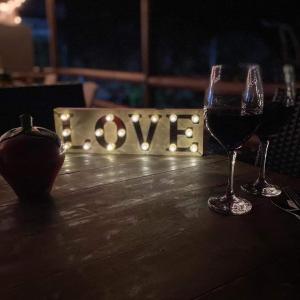 普罗维登西亚posada sunrise view vacation home的桌上的两杯酒,上面有“爱”字样的标志