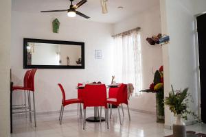 坎昆Casa Aurora的一间用餐室,配有红色的椅子和镜子