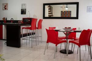 坎昆Casa Aurora的厨房配有红色的椅子和一张带镜子的桌子
