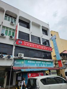 乔治市SS HOSTEL PENANG的白色的建筑,旁边标有标志