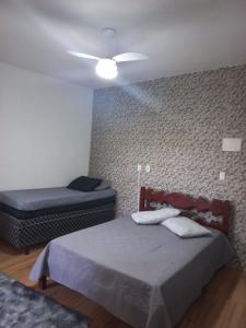 阿拉亚尔-杜卡布Kitnet Arraial do Cabo, Monte Alto.的一间卧室配有两张床和吊扇