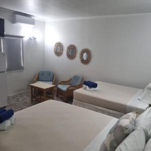 棕榈滩棕榈海滩度假村的一间设有两张床和一张桌子及椅子的房间