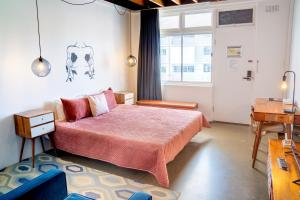 黄金海岸The Pink Hotel Coolangatta的一间卧室设有一张大床和一个窗户。