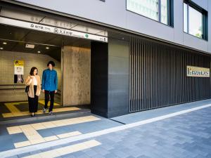 京都Hyatt Place Kyoto的走进建筑物的男人和女人