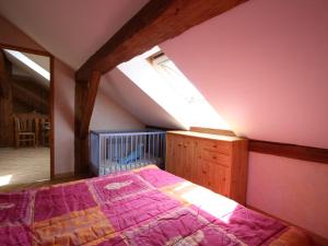 格尔蒙特维勒阿瓦尔Gîte Girmont-Val-d'Ajol, 4 pièces, 6 personnes - FR-1-589-50的一间卧室配有一张带紫色棉被的床