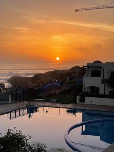 阿加迪尔Appartement vue sur mer的海洋上的日落,带游泳池