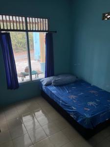 SoprayanHutama Kaliurang Guest House的一间卧室设有一张床和一个窗口