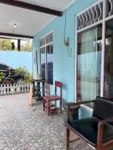 SoprayanHutama Kaliurang Guest House的一个带桌椅的庭院和蓝色的墙壁