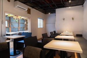 神户Hostel Ini kobe & Donut cafe的房间里的一排桌子和椅子