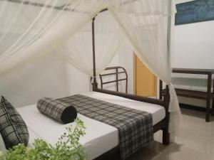 锡吉里亚Sigiriya Rock Gate Resort的一间卧室配有一张带天蓬的床