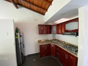 圣希尔Hermoso Apartamento en San Gil的厨房配有木制橱柜和不锈钢冰箱。