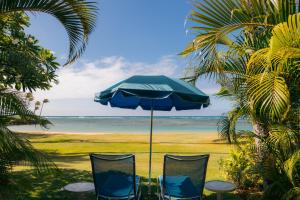 檀香山The Kahala Hotel and Resort的海滩上的两把椅子和一把遮阳伞