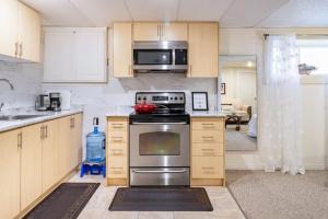 巴里KD Bachelor Suite - Lower Level的厨房配有不锈钢炉灶和微波炉