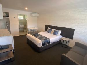 坎贝尔港南海洋汽车旅馆的一间卧室设有一张床和砖墙