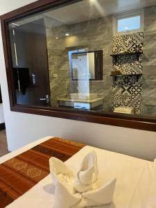 琅勃拉邦Villa Namkhan Heritage的一张床铺的房间墙上的镜子