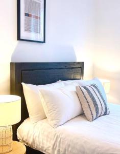 霍巴特Luxury Hobart City Fringe Home的床上铺有白色枕头的床