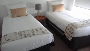 卡伦德拉浮石蓝度假酒店的两张睡床彼此相邻,位于一个房间里