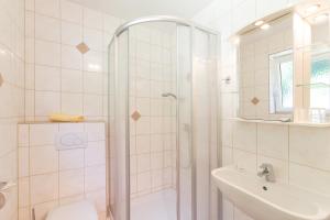 Wörschach莫泽豪斯酒店的带淋浴、卫生间和盥洗盆的浴室