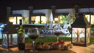 康考迪亚Amanzi Termal Rental的一张桌子,上面放着两杯葡萄酒和一盘食物