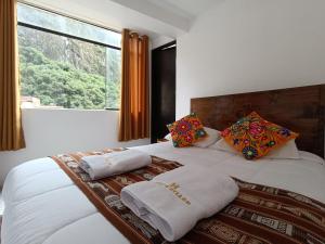 马丘比丘CUSI QOYLLOR的卧室配有带枕头的床铺和窗户。