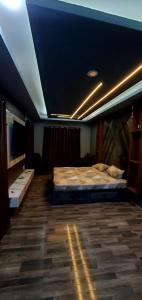 斯利那加Home sleeper的一间卧室设有一张大床和蓝色的天花板