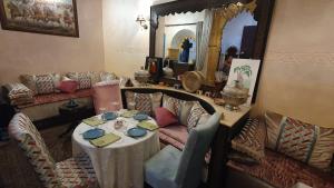 塞拉Riad La Porte du Bouregreg的客厅配有桌子和镜子