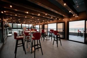 Shimen半岛海悦渡假会馆的一间酒吧,配有红色椅子,享有海景