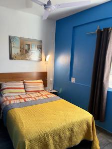 莫雷利亚Estancia María Bonita Morelia的蓝色卧室,配有一张黄色毯子床