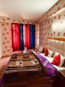 钱德加尔Sandhu Farm House的一间卧室配有一张大床,配有红色和蓝色的窗帘