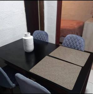 基多Minimalist House 1br El Bosque的一张带两把椅子的黑桌,上面有花瓶