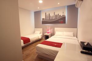 首尔Hotel Unique by Foret的酒店客房设有两张床,墙上挂着一张照片。