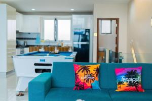 邦萨雷Ocean Pool Villa Pattaya的客厅配有带热带枕头的蓝色沙发