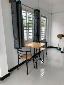 贡布Home Daun Kam的一间带木桌和椅子的用餐室