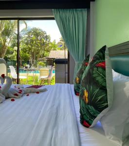 芭东海滩NR Nanai Patong的一间卧室配有一张带白色床单的床和一扇窗户。